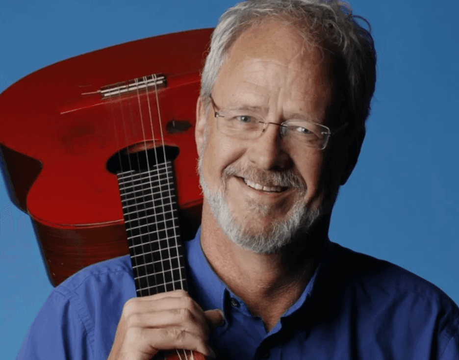 Gordy Pratt, studio portrait with a red guitar